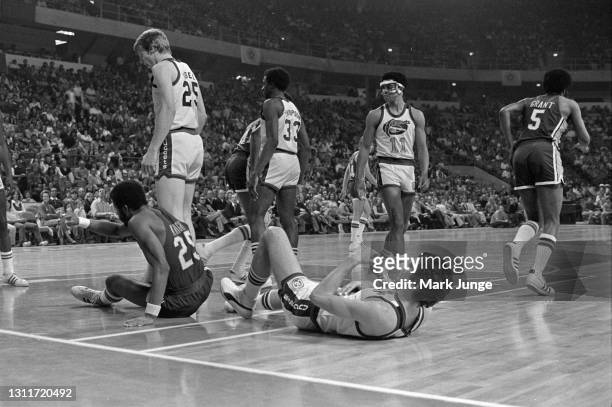 Indiana Pacers forward Billy Knight and Denver Nuggets forward Bobby Jones are knocked to the floor after a collision during an ABA basketball game...