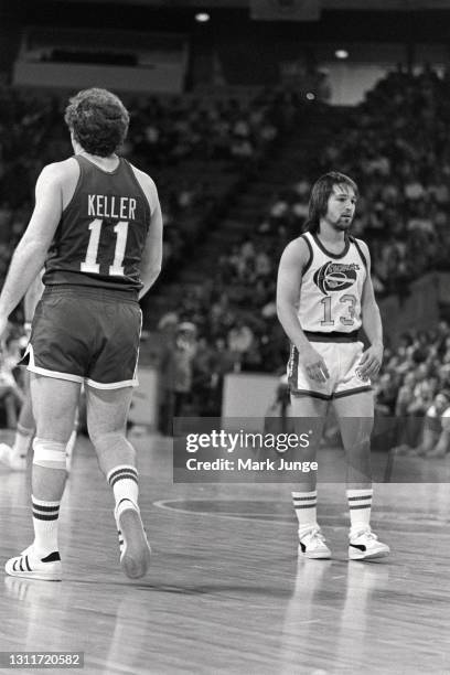 Indiana Pacers guard Bill Keller walks past Denver Nuggets guard Monte Towe during an ABA basketball game at McNichols Arena on March 26, 1976 in...