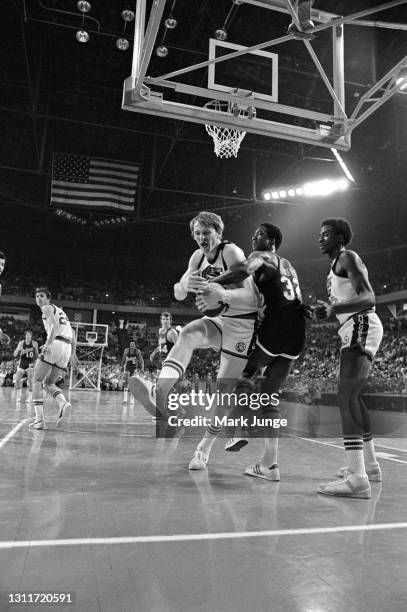 Indiana Pacers forward Dan Roundfield tries to take the ball away from Denver Nuggets center Dan Issel during an ABA basketball game at McNichols...