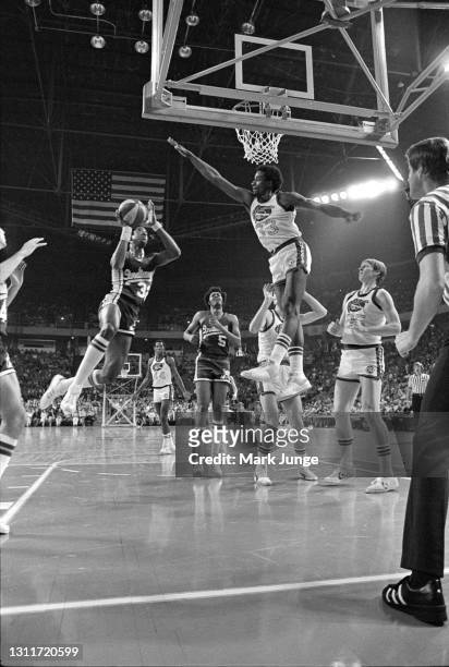 Denver Nuggets forward David Thompson leaps to block a layup by Indiana Pacers forward Dan Roundfield during an ABA basketball game at McNichols...