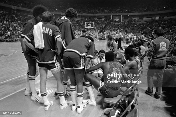 Indiana Pacers coach William Robert “Slick” Leonard and his assistant Jerry Oliver kneel during a team time out in an ABA basketball game against the...