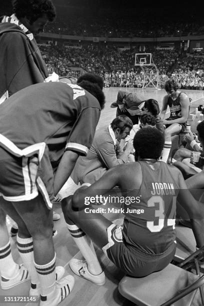 Indiana Pacers coach William Robert “Slick” Leonard and his assistants huddle with their team during an ABA basketball game timeout against the...