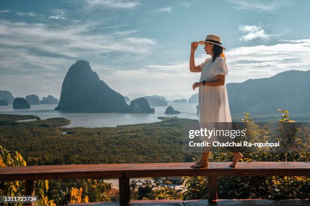 woman with the white dress sit and see the mountain in early morning at samet nangshe viewpoint - phuket beach stock-fotos und bilder