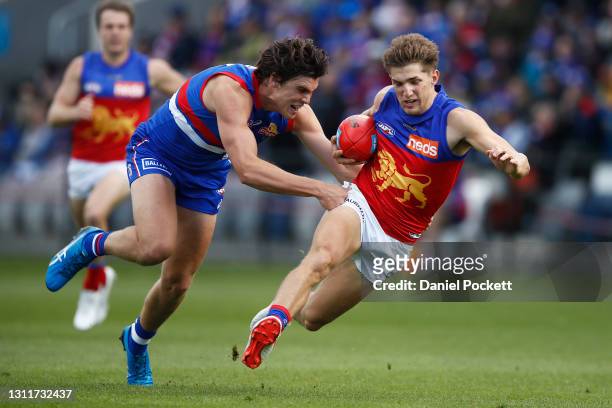 Zac Bailey of the Lions is tackled by Lewis Young of the Bulldogs during the round four AFL match between the Western Bulldogs and the Brisbane Lions...