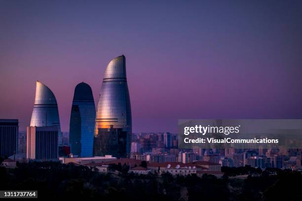 夕暮れ時のバクーの炎の塔。 - アゼルバイジャン ストックフォトと画像