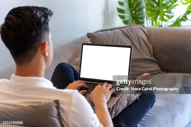 young man using laptop with blank screen - asian man home laptop stock pictures, royalty-free photos & images