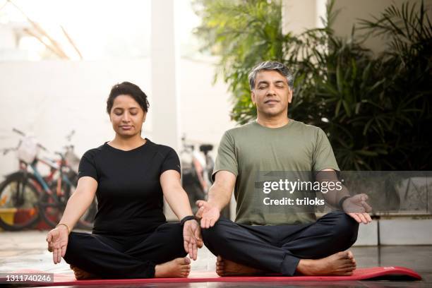 couple meditating in lotus position - asian couple exercise stock pictures, royalty-free photos & images