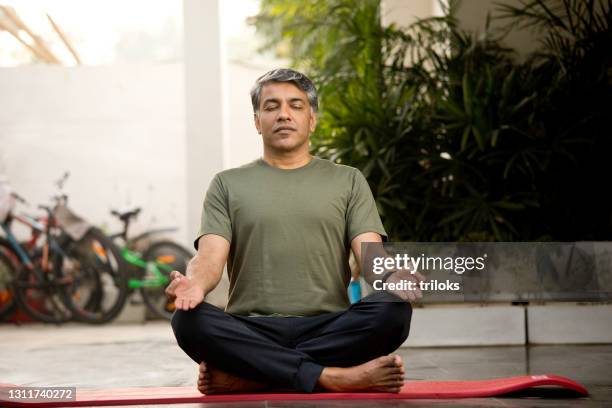 man meditating in lotus position - meditação imagens e fotografias de stock