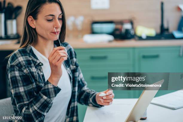 mujer realizando hisopo autoprueba y prueba rápida de coronavirus/covid-19. - instrumento de la reacción en cadena de la polimerasa fotografías e imágenes de stock