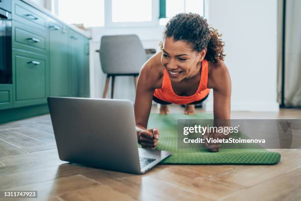 mujer deportiva haciendo ejercicio en casa. - flexiones fotografías e imágenes de stock