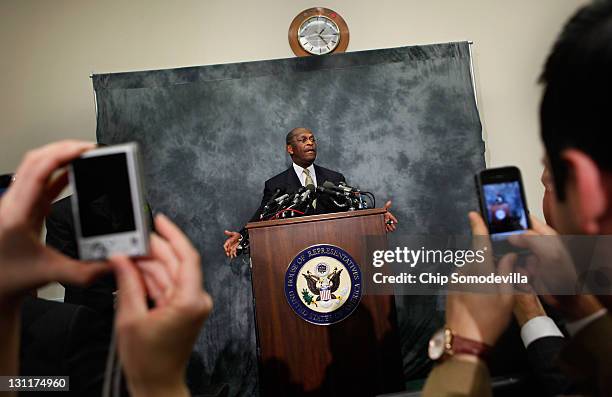 Capitol Hill staffers photograph Republican presidential candidate and former CEO of Godfather's Pizza Herman Cain as he participates in a discussion...