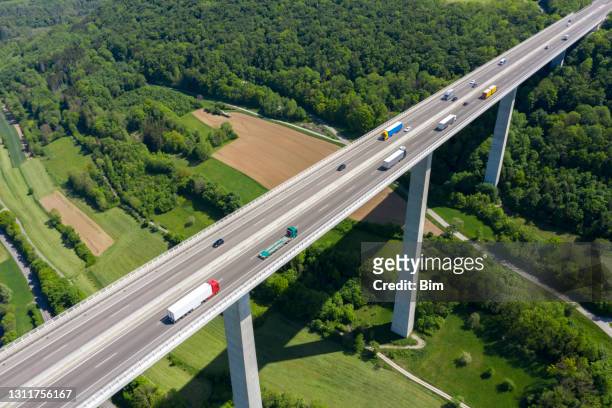 lkw-verkehr auf der autobahnbrücke, luftbild - deutsche autobahn stock-fotos und bilder