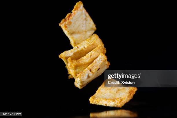 fried tofu with red chili pepper flying in mid air captured in high speed. - tofu stock-fotos und bilder