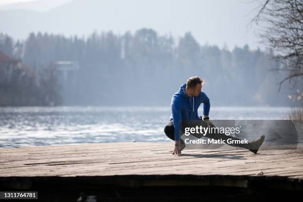 junger mann, der beinstreckung macht - laufmasche stock-fotos und bilder
