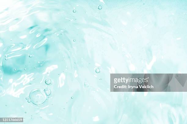 abstract background with moisturizing cleansing cosmetic gel, pure water or face serum, essential oil with oxygen aqua bubbles and waves. - refrescante fotografías e imágenes de stock