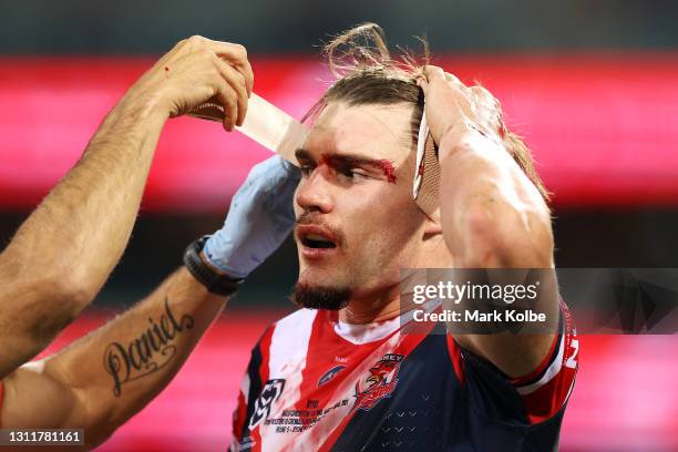 Angus Crichton of the Roosters is strapped up as he bleeds from a cut on his brow during the round five NRL match between the Sydney Roosters and the...