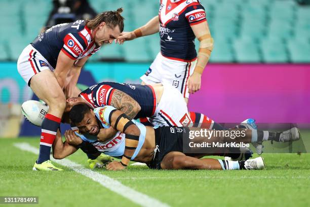 Ronaldo Mulitalo of the Sharks is tackled into touch by Angus Crichton and Jared Waerea-Hargreaves of the Roosters during the round five NRL match...