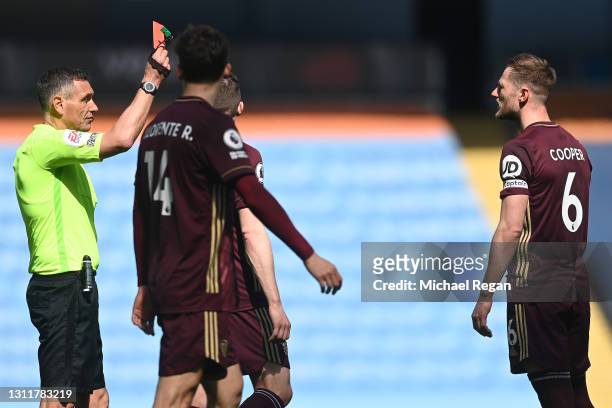 Liam Cooper of Leeds United is shown a red card and sent off by referee Andre Marriner during the Premier League match between Manchester City and...