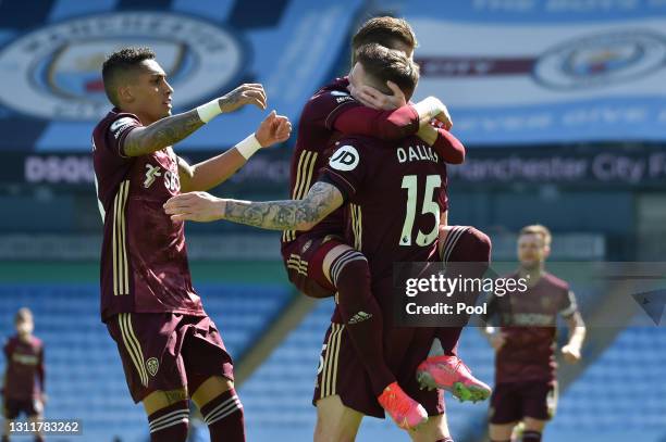 Stuart Dallas of Leeds United celebrates with Ezgjan Alioski and Raphinha after scoring their team's first goal during the Premier League match...