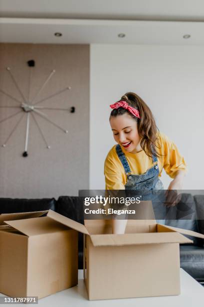 garota feliz desempacotando roupas após compras online - unboxing - fotografias e filmes do acervo