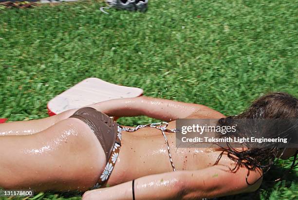 woman lying in grass - tween girl swimsuit stockfoto's en -beelden