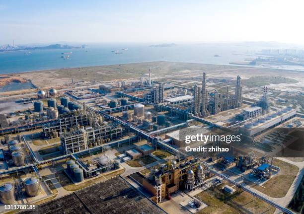 drone view of chemical plant by the sea in sunny day - overlooking factory stock pictures, royalty-free photos & images