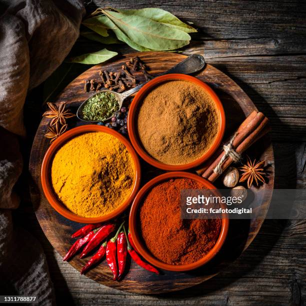 indiska kryddor skjutna ovanifrån på rustikt bord - indian spices bildbanksfoton och bilder