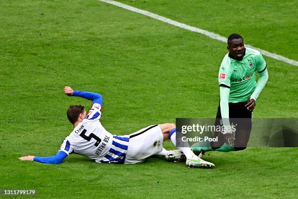 Marcus Thuram of Borussia Moenchengladbach is fouled by Niklas Stark of Hertha Berlin leading to a penalty during the Bundesliga match between Hertha...
