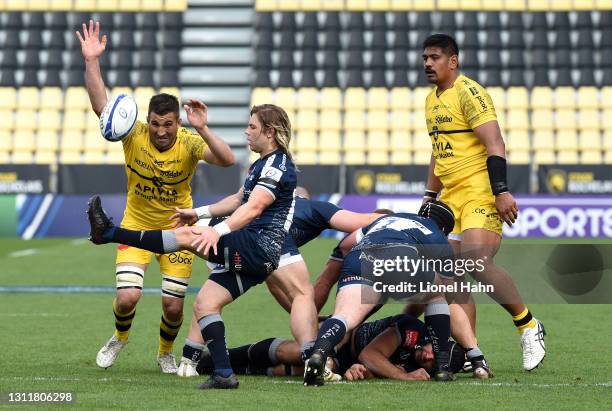 Faf de Klerk of Sale Sharks box kicks the ball clear under pressure from Romain Sazy of La Rochelle during the Quarter Final Champions Cup match...