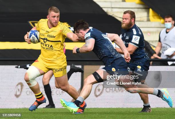 Pierre Bourgarit of La Rochelle is tackled by Tom Curry of Sale Sharks during the Quarter Final Champions Cup match between La Rochelle and Sale...