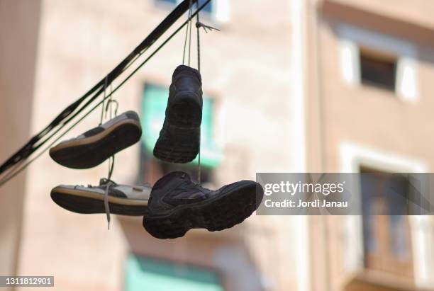 boots hanging from a cable in the city of barcelona. - sapato metalizado imagens e fotografias de stock