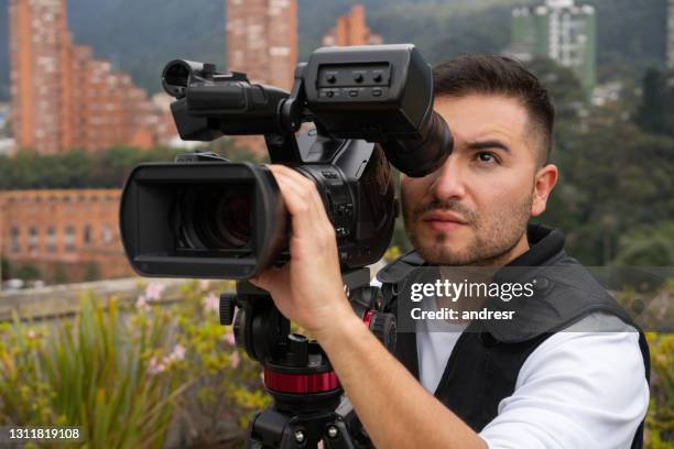 cameraman outdoors recording breaking news - cinematographer imagens e fotografias de stock