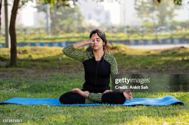 young woman doing yoga and exercise at park - pranayama stock pictures, royalty-free photos & images