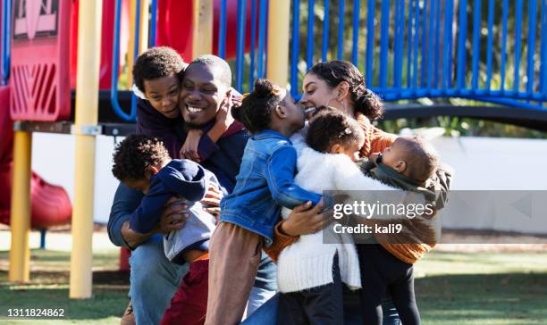 multi-racial family, five children on playground hugging - family with five children stock pictures, royalty-free photos & images