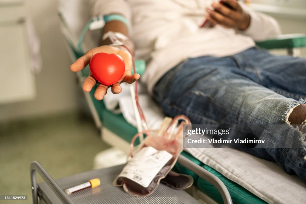 Donor squeezing the heart-shaped ball during blood donation