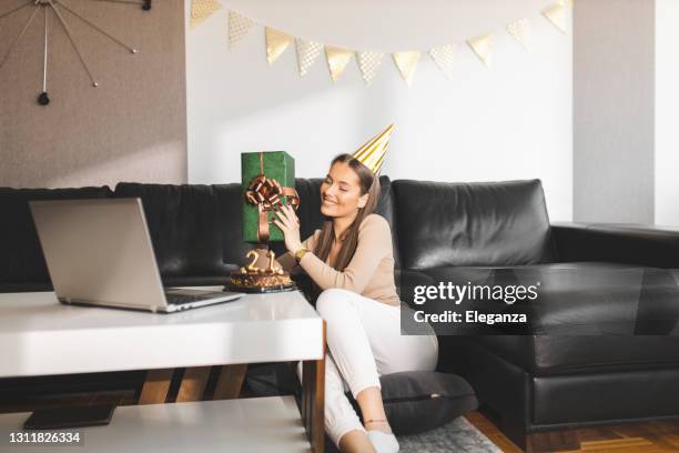 girl opening gifts and celebrating her 21st birthday with friends on video call - zoom birthday stock pictures, royalty-free photos & images