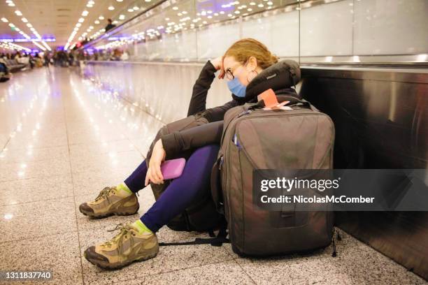 young female traveller napping as she waits forever at the airport terminal - cancellation stock pictures, royalty-free photos & images