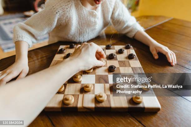 personal perspective of an adult playing checkers with a child - chess championship stock pictures, royalty-free photos & images