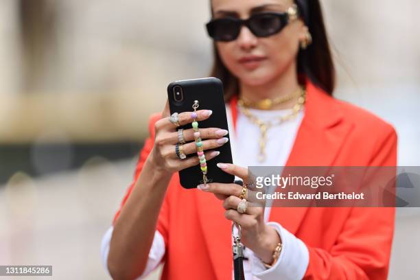 Patricia Gloria Contreras wears a bandanna, sunglasses from Versace, an orange / red blazer oversized jacket from Nastygal, a white Balmain logo...