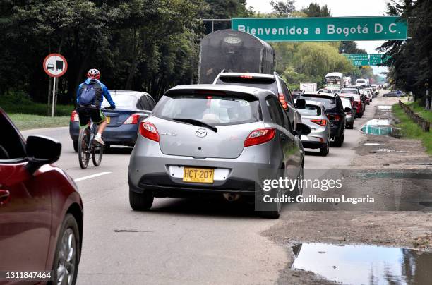 Traffic jam along the highway entering the city due to a long line of vehicles waiting to enter a drive-thru vaccination center mounted at Bima...