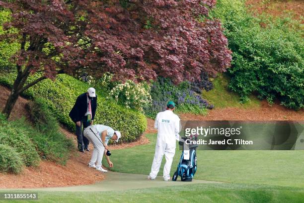 Jordan Spieth of the United States gets a ruling on the 12th hole during the third round of the Masters at Augusta National Golf Club on April 10,...