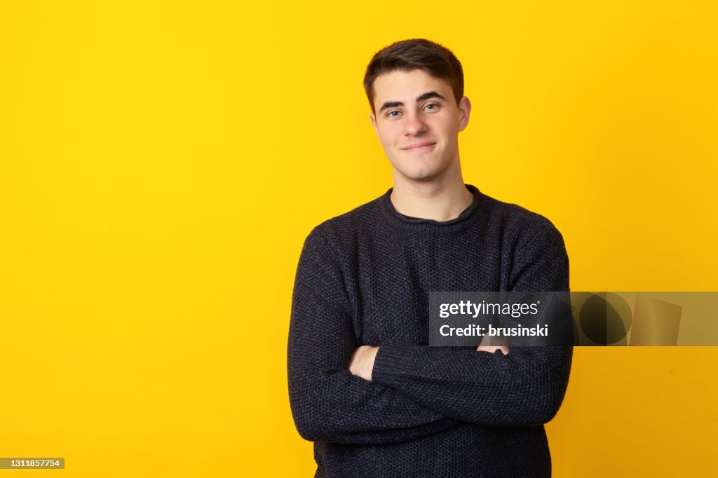 Studioporträt eines 19-jährigen Mannes auf gelbem Hintergrund