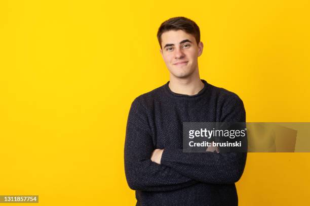 studio portrait of 19 year old man on yellow background - young men stock pictures, royalty-free photos & images