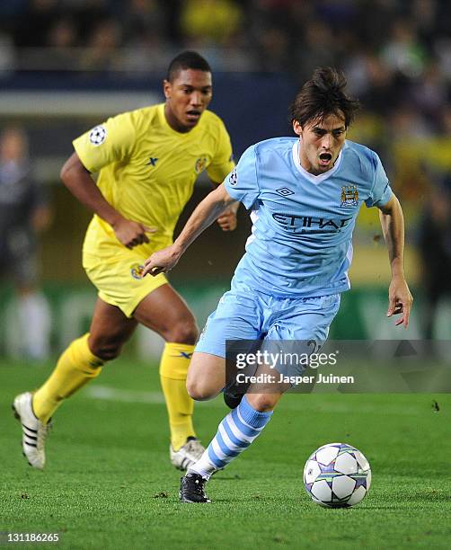 David Silva of Manchester City FC runs for the ball with Jonathan De Guzman of Villarreal CF during the UEFA Champions League group A match between...