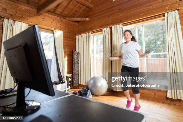 een vrouw touw-minder het overslaan thuis voor pc-scherm - spring training stockfoto's en -beelden
