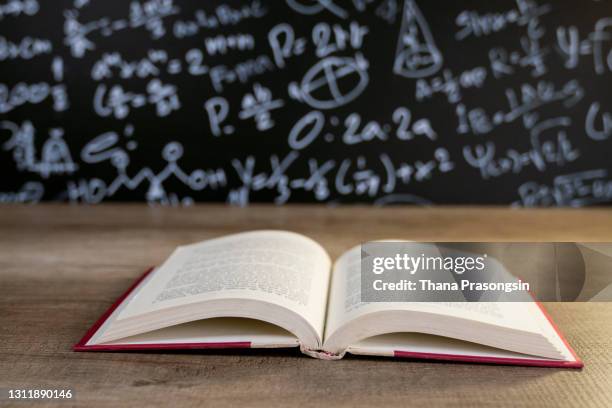 back to school supplies. books and blackboard on wooden background - desabrochado fotografías e imágenes de stock