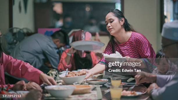 iftar ramadan hari raya malaysian muslim multi generation family enjoying dinner at home in dining room - big family dinner stock pictures, royalty-free photos & images