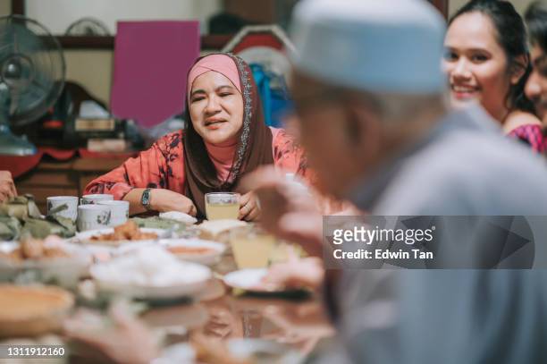 iftar ramadan hari raya malaysian muslim multi generation family enjoying dinner at home in dining room - iftar stock pictures, royalty-free photos & images