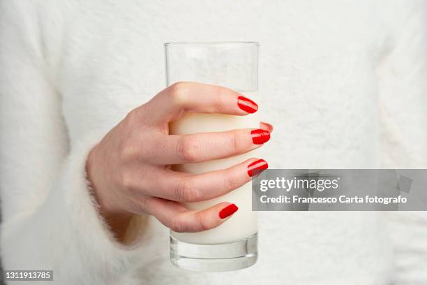 woman holding glass of milk - レッドマニキュア ストックフォトと画像