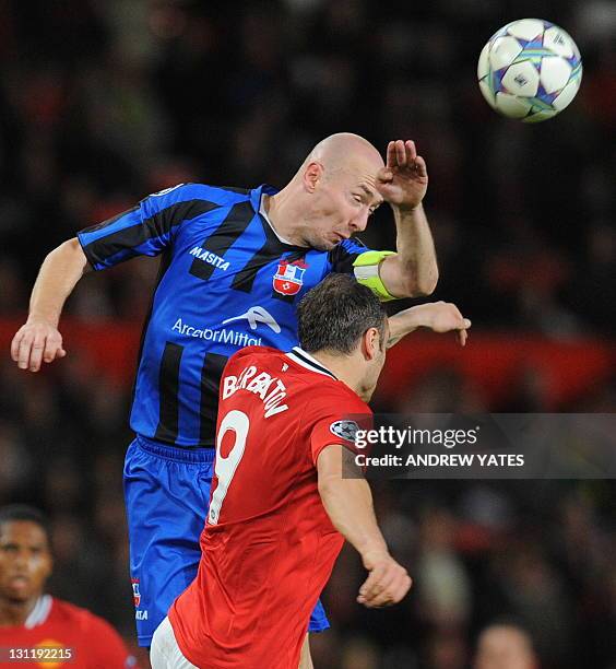 Otelul Galati's Romanian defender Sergiu Costin heads the ball next to Manchester United's Bulgarian forward Dimitar Berbatov during the UEFA...